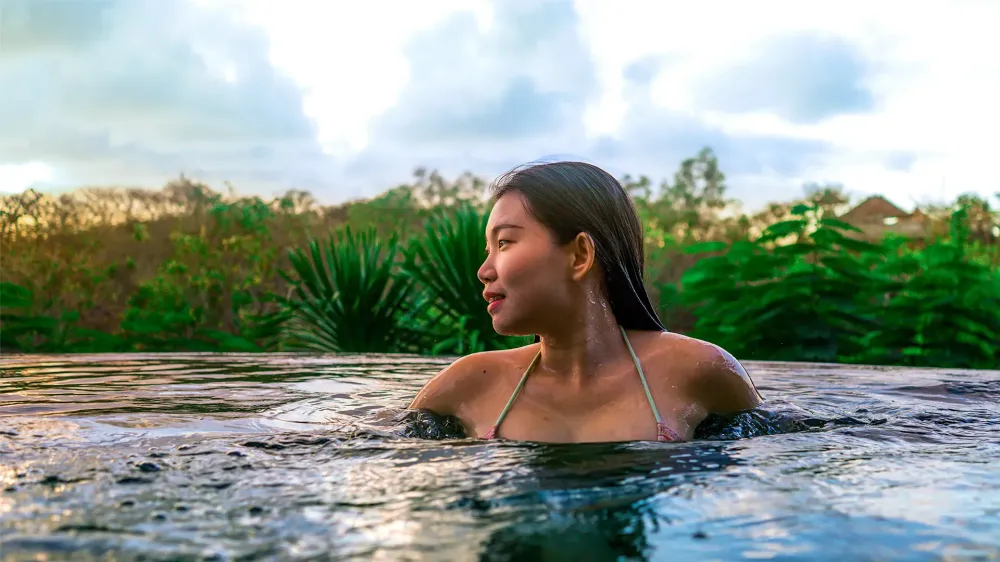woman infinity pool tropical vacation